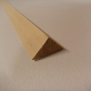 Ein dreieckiger Holzstab liegt auf einer weißen Oberfläche, mit einer Ansicht auf die Schnittkante, die die dreieckige Form zeigt.