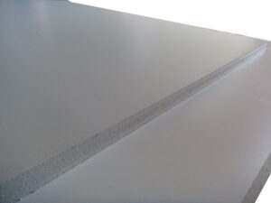 Ein Stapel weißer Gipskartonplatten liegt übereinander.