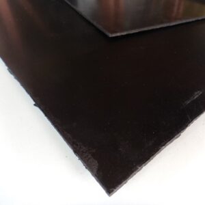 Nahaufnahme von zwei übereinanderliegenden, schwarzen Gummi- oder Kunststoffplatten auf einer weißen Oberfläche.