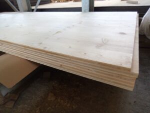 Ein Stapel aus Holzplatten in einem Lagerraum aufbewahrt.
