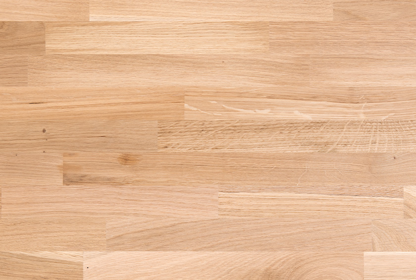 Helle Holzoberfläche mit sichtbarer Maserung und vereinzelten Astknoten.