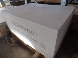 Ein Stapel von Aquapanel-Zementplatten für den Außenbereich liegt auf einer Palette in einem Lager.