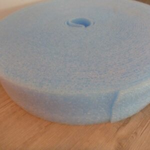 Große Rolle blaue Schaumstoff- oder Polsterfolie, die auf einem Holzboden liegt.