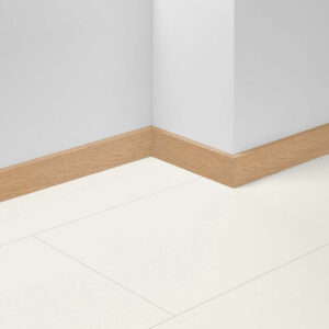Ecke eines Raumes mit weißer Wand und beigem Holzboden, ergänzt durch eine helle Holzsockelleiste.