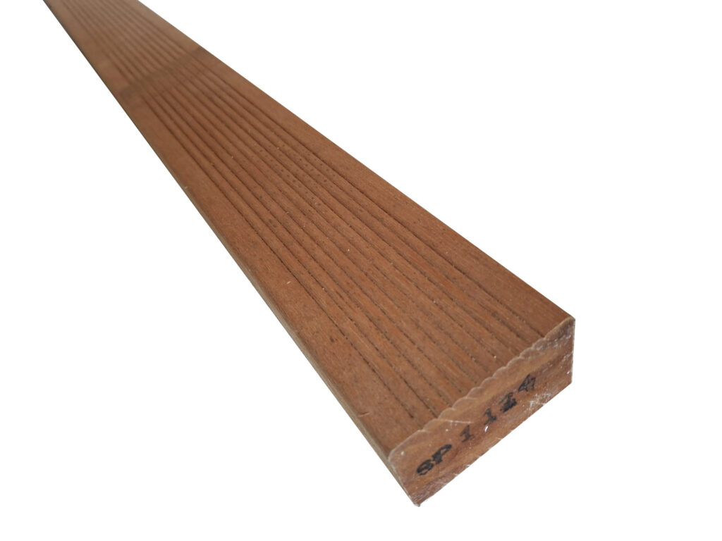 Ein braunes Holzbrett mit feinen, parallelen Rillen auf der Oberfläche, das an einem Ende mit einer Markierung gekennzeichnet ist.