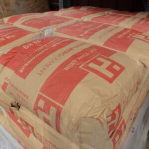 Ein Stapel von Papiersäcken mit roter Aufschrift und Logo, die 25 kg Portlandzement enthalten, auf einer Palette gestapelt.
