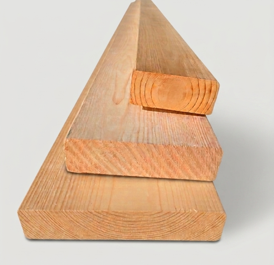 Drei gestapelte Holzbretter in verschiedenen Größen vor einem grauen Hintergrund.