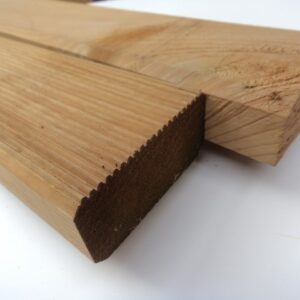 Nahaufnahme von zwei nebeneinander liegenden Holzbohlen, eine mit geriffelter Oberfläche, auf einem weißen Hintergrund.