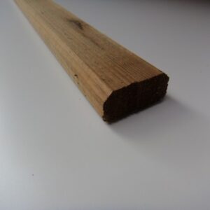 Nahaufnahme eines abgewinkelten Holzstücks auf einer weißen Oberfläche.