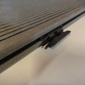 Nahaufnahme eines Kastenschlosses an einer Metallplatte mit parallelen Rillen, das in der Kante der Platte eingefügt ist.