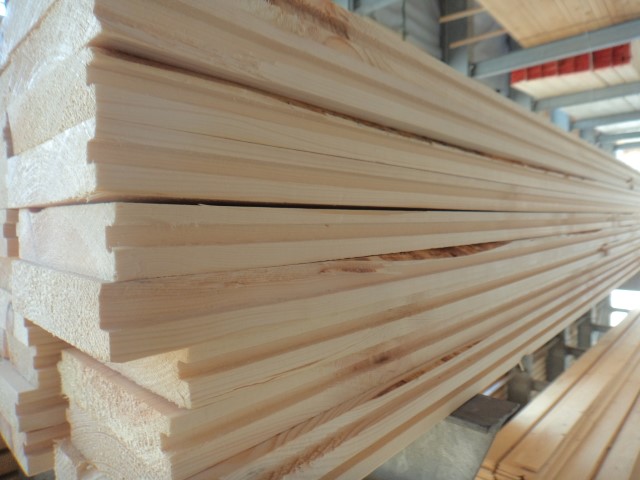 Ein Stapel von frisch geschnittenem Holz mit Nut und Feder in einem Lager oder einer Werkstatt.