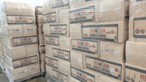 Gestapelte Paletten mit in Plastik verpackten Säcken, die Hobelspäne der Marke "Peer Span" enthalten.