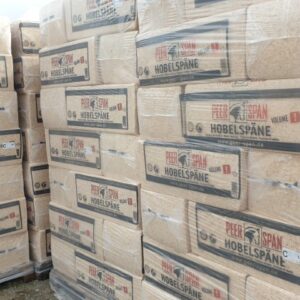 Gestapelte Paletten mit in Plastik verpackten Säcken, die Hobelspäne der Marke "Peer Span" enthalten.