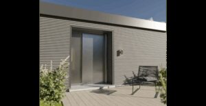 Modernes Gebäude mit Metallfassade und Glastür, davor ein schwarzer Stuhl auf einer Holzterrasse, umgeben von Pflanzen.