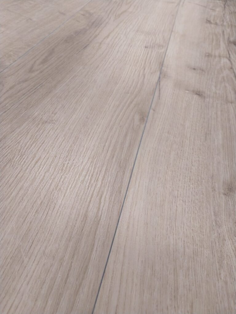 Holzfußboden mit hellen, naturbelassenen Dielen, die eine Holzmaserung aufweisen.