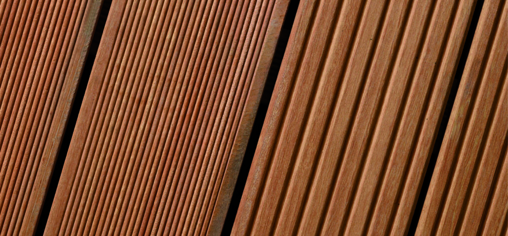 Nahaufnahme von braunem Holz mit parallel verlaufenden Rillenmustern.