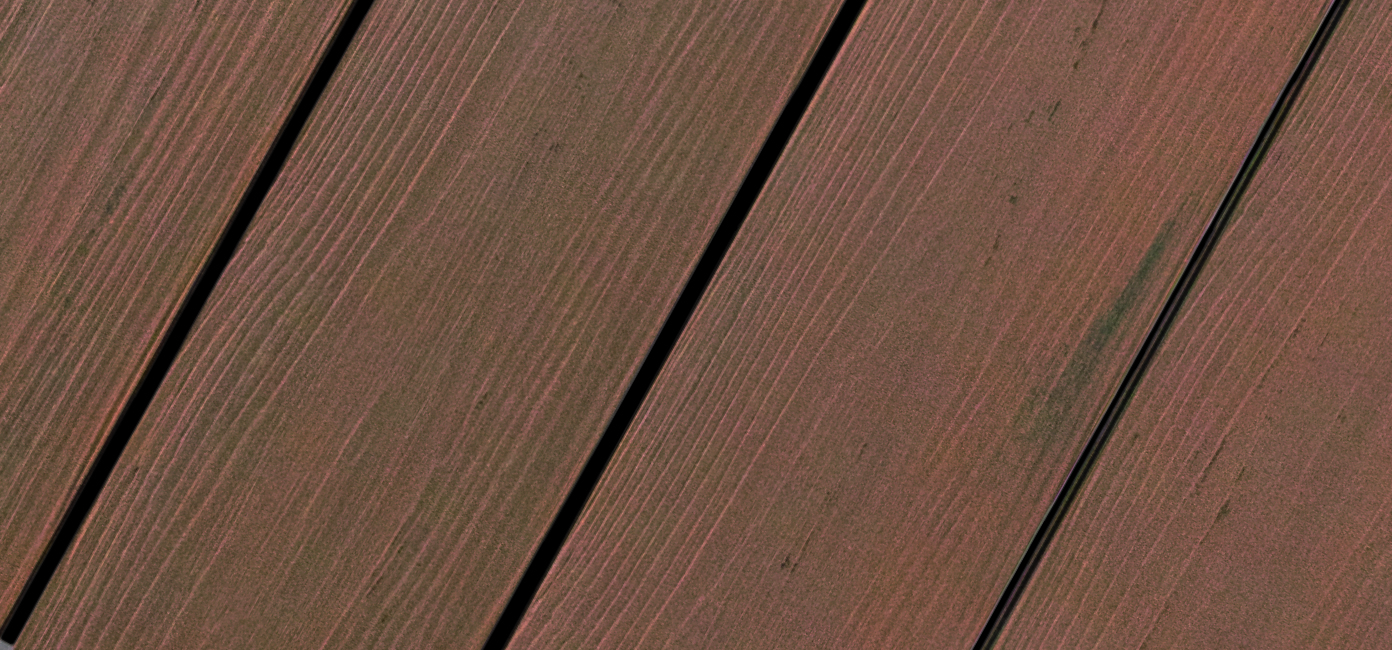 Nahaufnahme von diagonal verlegten Holzdielen mit rötlich-brauner Färbung und feiner Maserung.