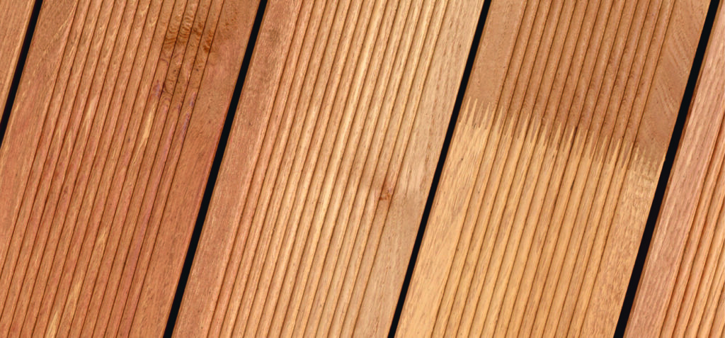 Holzbretter mit geriffelter Oberfläche in paralleler Anordnung, ein Brett zeigt einen helleren, frisch bearbeiteten Abschnitt.