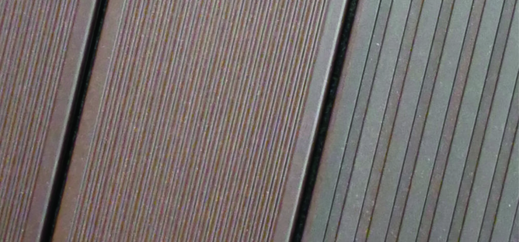 Nahaufnahme von zwei nebeneinanderliegenden braunen und grauen Holzpaneelen mit feinen parallelen Linien.