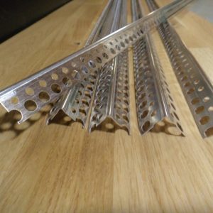 Metallschienen mit kreisförmigen Löchern liegen nebeneinander auf einer Holzoberfläche.