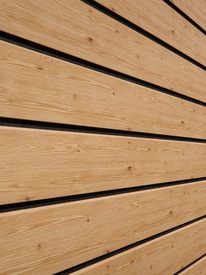 Fassade_Kunststoff (11) Eine Holzwand besteht aus horizontalen, gleichmäßigen Brettern mit leichter Maserung.